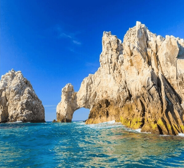 Sea arches stretching out over bright blue water, El Arco, Los Cabos